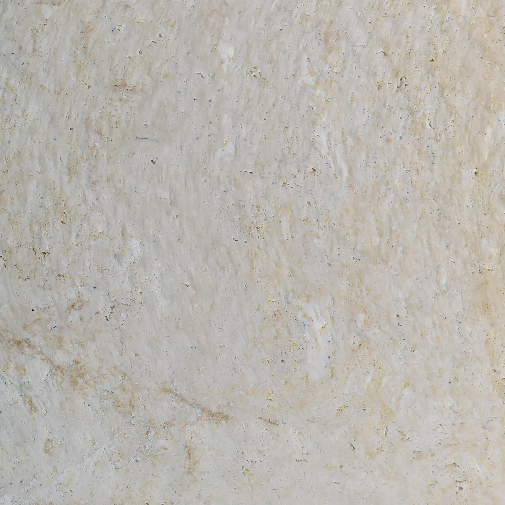 Macro of cream limestone surface with ivory veil veining and fine pitting, honed matte finish, full-frame texture.