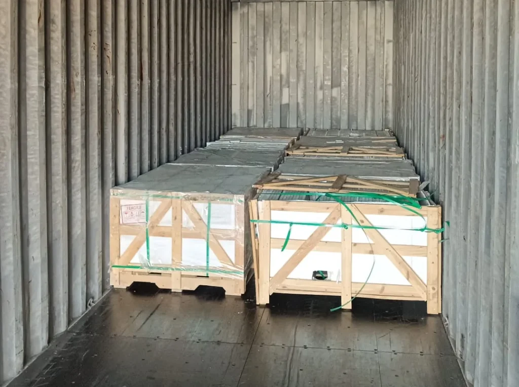 Crates of stone at the far end of an empty 40 ft container during loading.