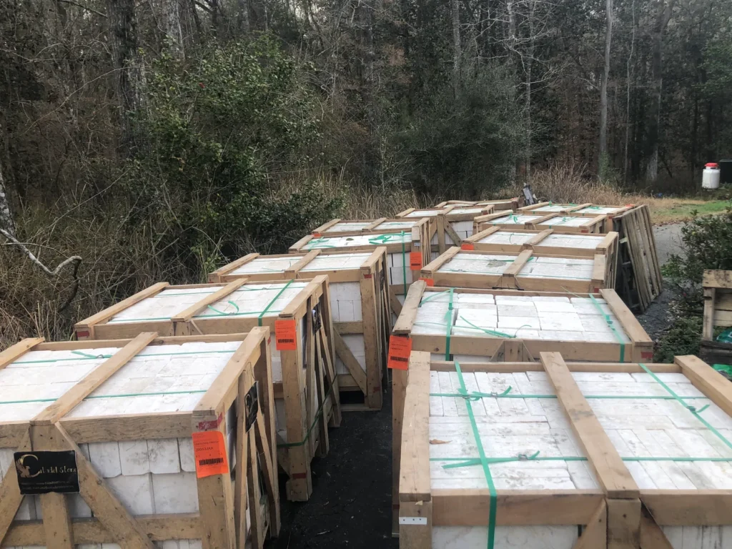 Several crates of white stone on a wooded site.