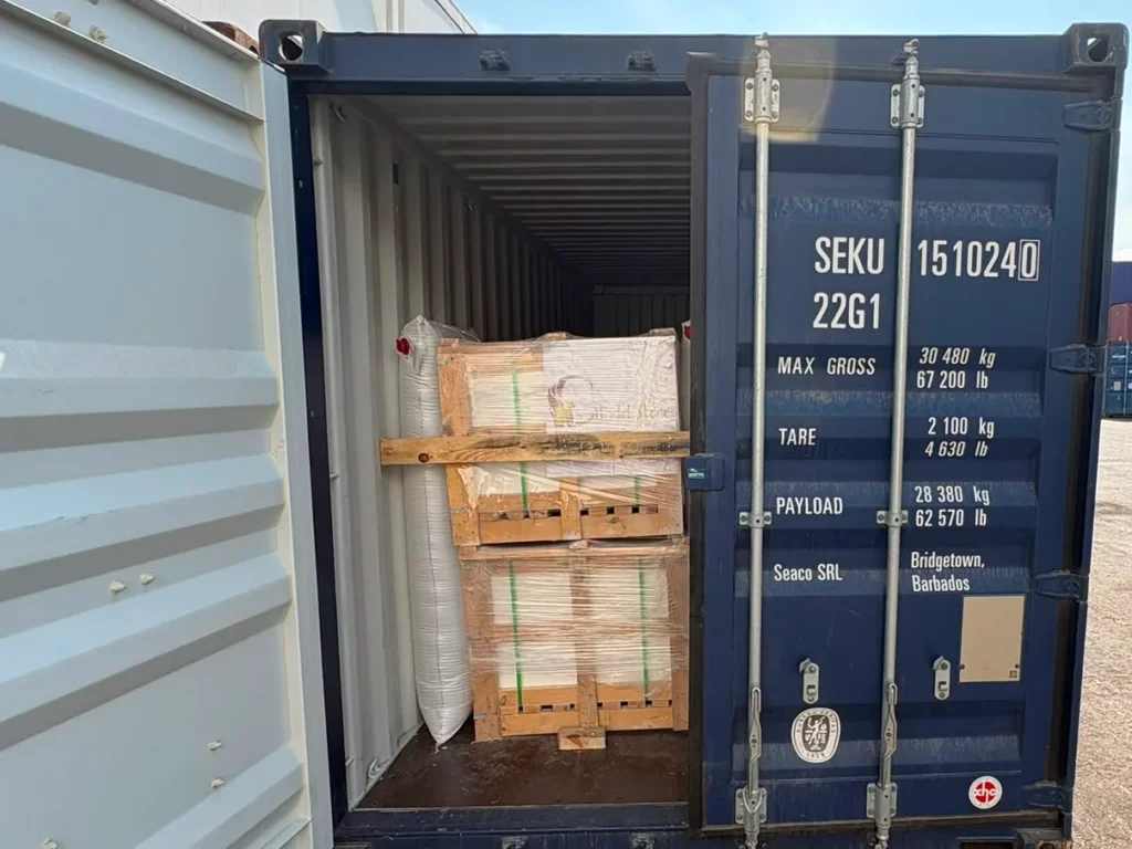 Blue container SEKU 151024 0 with one door open, showing crates stacked two high and braced with a timber bar.