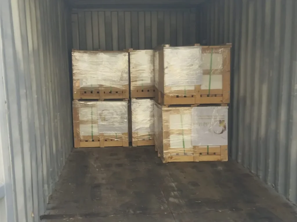 The first crates of stone stacked two high at the far end of an otherwise empty container.