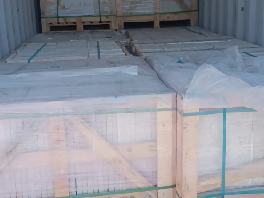 Film-wrapped crates of stone inside a container.