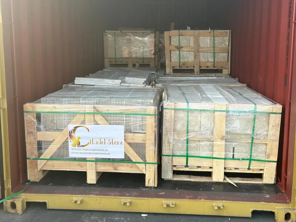 Crates of stone stacked two high inside a container.