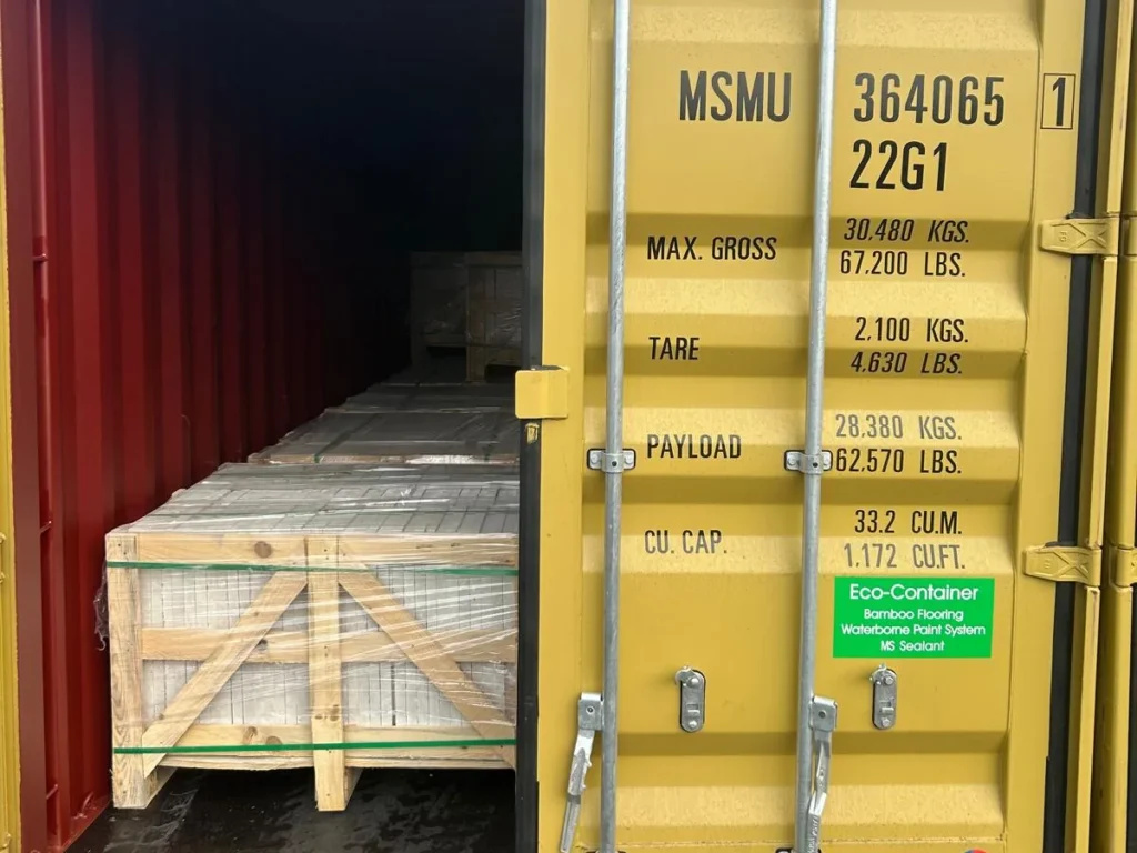 Yellow container MSMU 364065 1 with one door open and crates of stone inside.