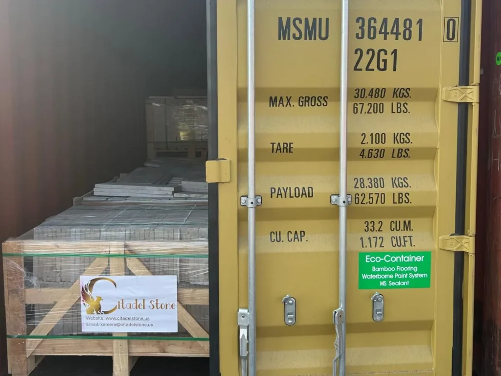 Yellow container MSMU 364481 0 with one door open and crates of stone inside.