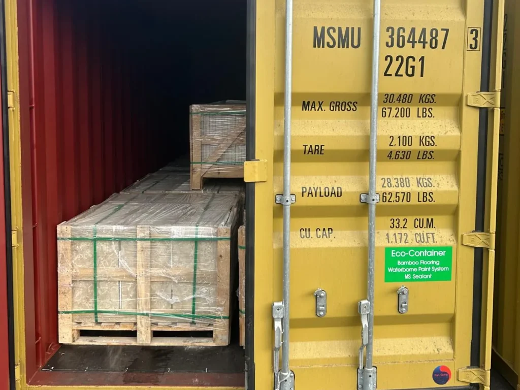 Yellow container MSMU 364487 3 with one door open and crates of stone inside.