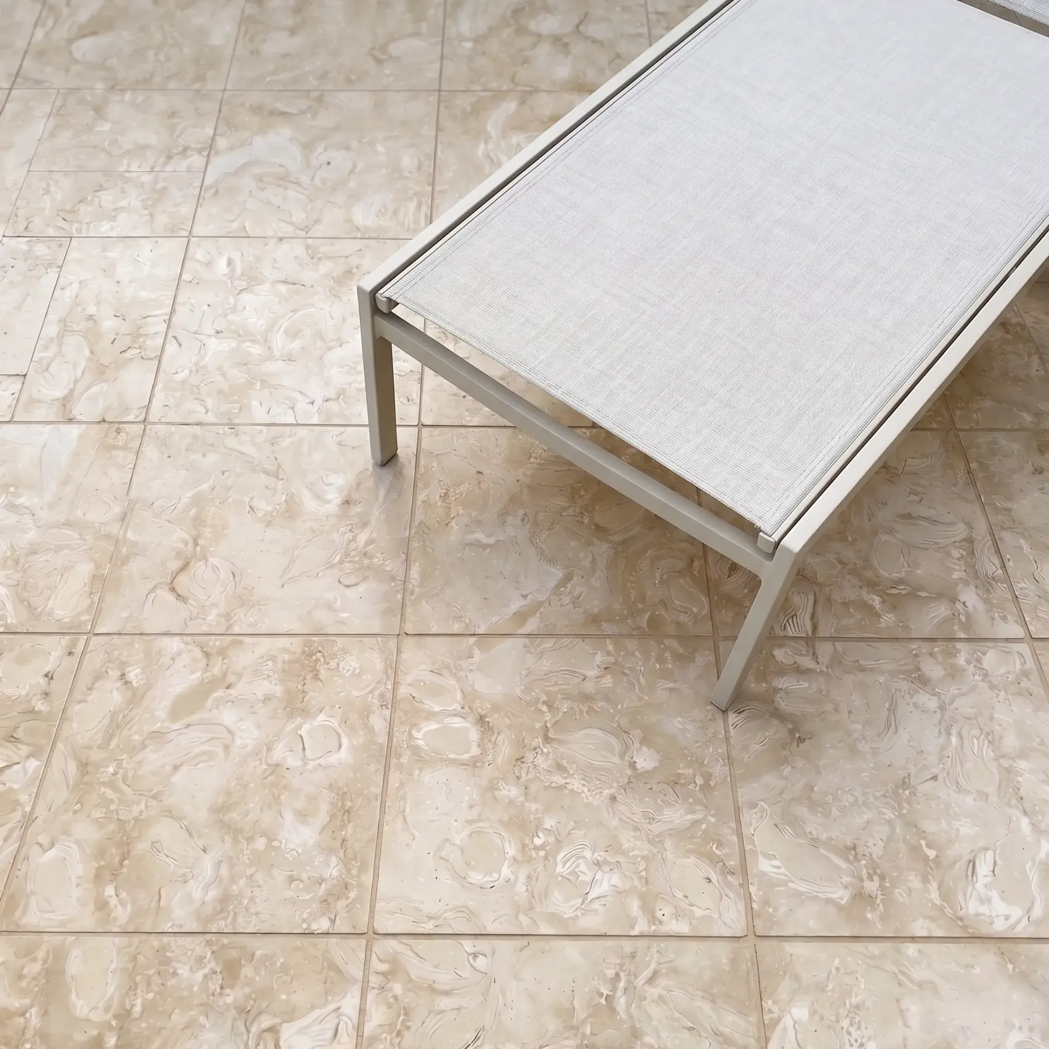 Overhead beige sling lounger on fossil beige shellstone square tiles with tight joints.