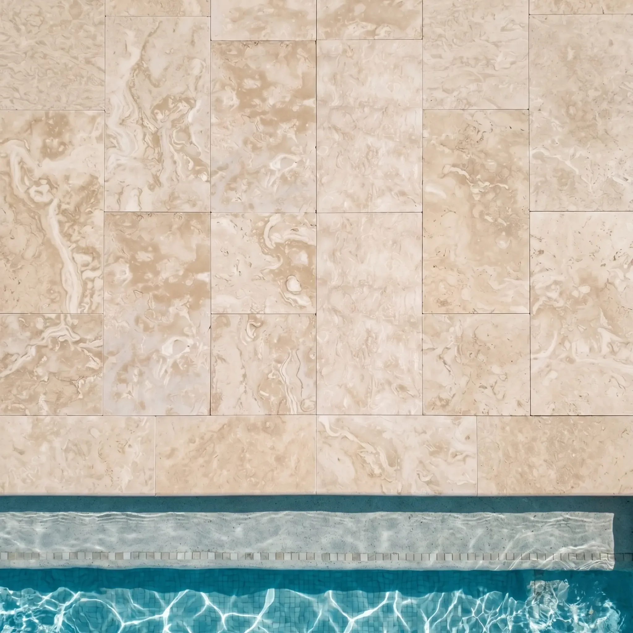 Top-down beige travertine pavers in vertical running bond with bullnose coping and waterline tile at a turquoise pool.